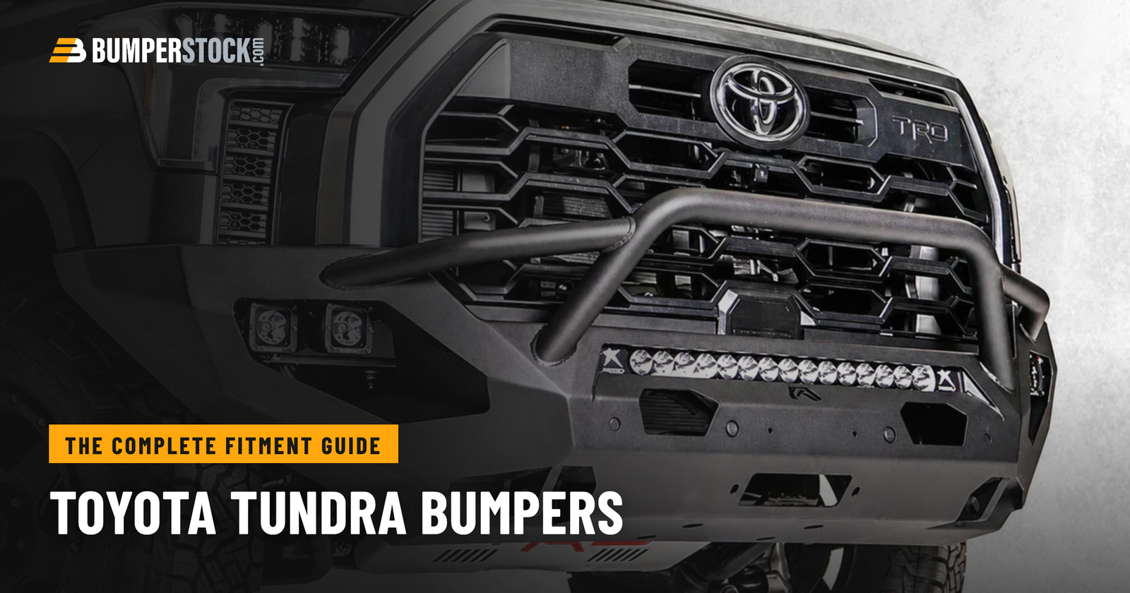 Close-up of a 2022-2026 Toyota Tundra TRD front end with a black aftermarket steel front bumper, center guard, cube lights, and LED light bar